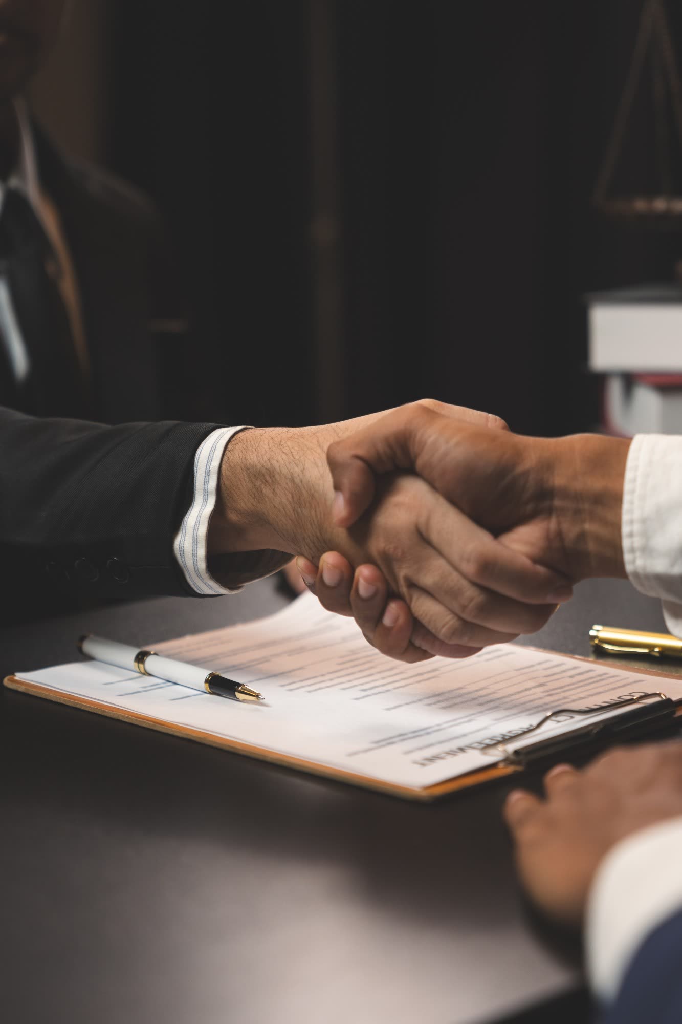 Apretón de manos sobre un contrato firmado